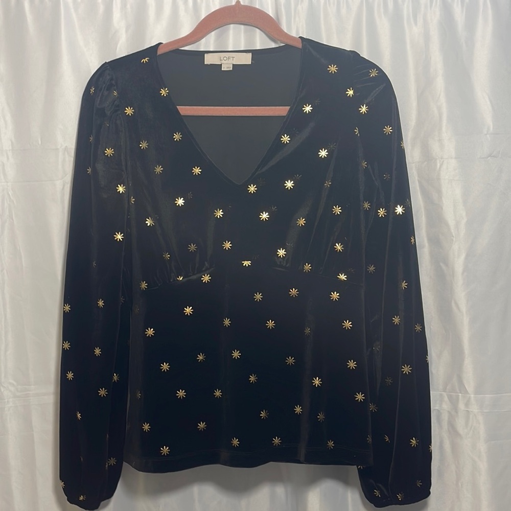 Black velour v neck peplum style sweatshirt with gold metallic star print.